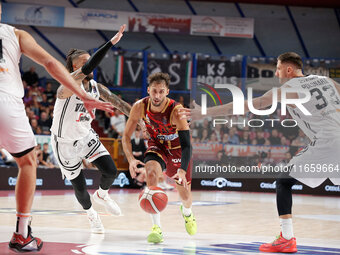 Umana Reyer's Davide Moretti competes against Virtus Bologna's Achille Polonara and Daniel Hackett during the Italian LBA basketball champio...