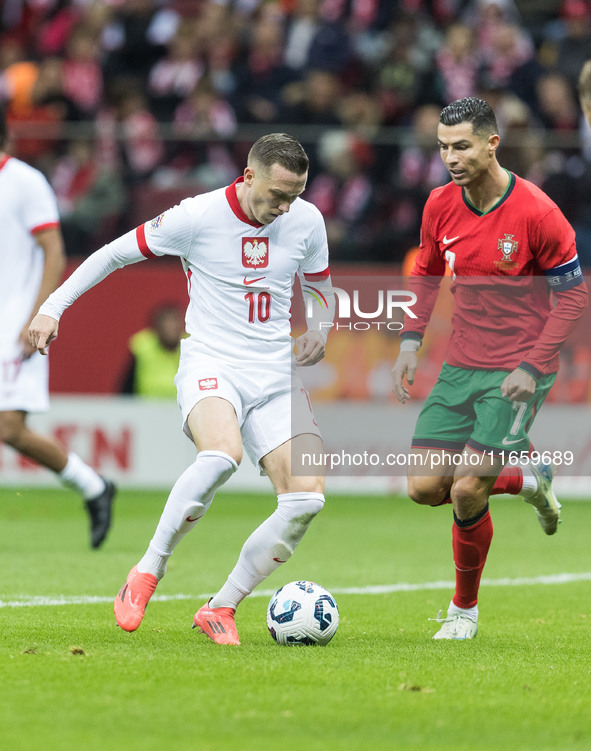 Piotr Zielinski , Cristiano Ronaldo  during UEFA Nations League match Poland vs Portugal in Warsaw Poland on 12 October 2024. 