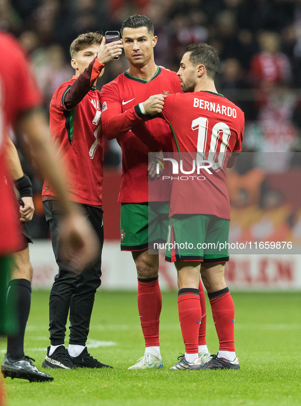 A fan takes a picture with Cristiano Ronaldo , Bernardo Silva  during UEFA Nations League match Poland vs Portugal in Warsaw Poland on 12 Oc...