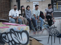 Iranian youths sit together while waiting to watch a freestyle bicycle competition at the Navid BMX Bike Park in southern Tehran, Iran, on O...