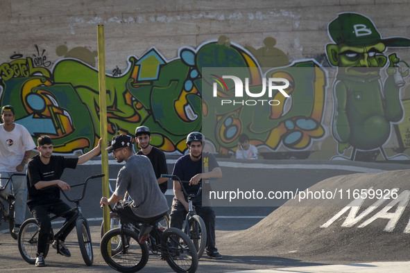 Iranian youths sit together on their BMX bikes while they wait to perform in a freestyle bicycle competition at the Navid BMX Bike Park in s...