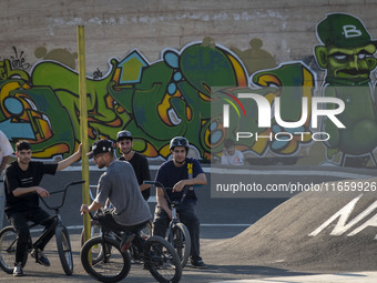 Iranian youths sit together on their BMX bikes while they wait to perform in a freestyle bicycle competition at the Navid BMX Bike Park in s...