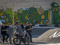 Iranian youths sit together on their BMX bikes while they wait to perform in a freestyle bicycle competition at the Navid BMX Bike Park in s...