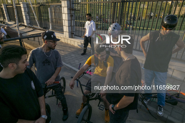 Iranian youths sit together on their BMX bikes while they wait to perform in a freestyle bicycle competition at the Navid BMX Bike Park in s...