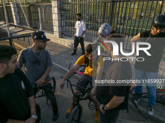 Iranian youths sit together on their BMX bikes while they wait to perform in a freestyle bicycle competition at the Navid BMX Bike Park in s...