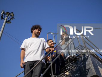 Iranian youths sit together during a freestyle bicycle competition at the Navid BMX Bike Park in southern Tehran, Iran, on October 11, 2024....