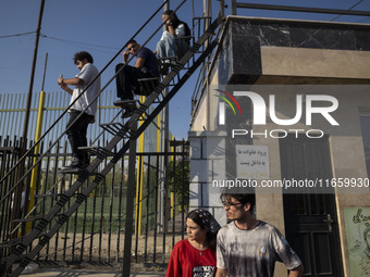 Iranian youths watch a freestyle bicycle competition at the Navid BMX Bike Park in southern Tehran, Iran, on October 11, 2024. (