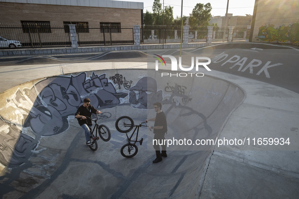 Two Iranian participants warm up before taking part in a freestyle bicycle competition at the Navid BMX Bike Park in southern Tehran, Iran,...