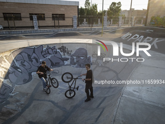 Two Iranian participants warm up before taking part in a freestyle bicycle competition at the Navid BMX Bike Park in southern Tehran, Iran,...