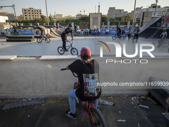 Iranian youths warm up before participating in a freestyle bicycle competition at the Navid BMX Bike Park in southern Tehran, Iran, on Octob...