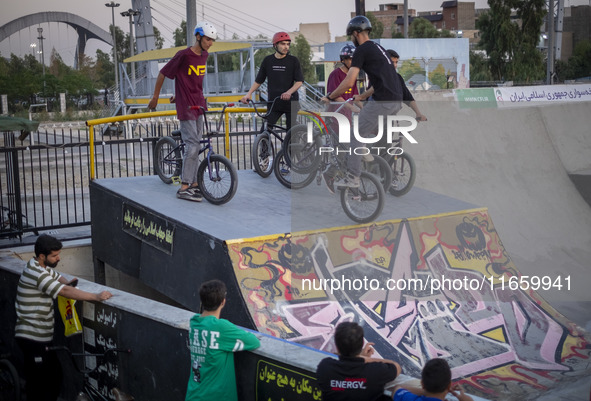 Young Iranian men stand with their BMX bikes at the start point before participating in a freestyle bicycle competition at the Navid BMX Bik...