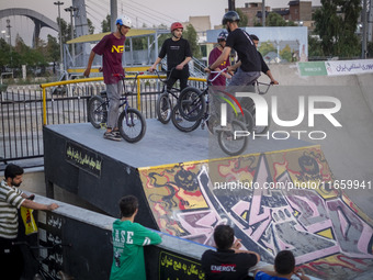 Young Iranian men stand with their BMX bikes at the start point before participating in a freestyle bicycle competition at the Navid BMX Bik...