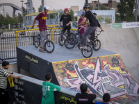 Young Iranian men stand with their BMX bikes at the start point before participating in a freestyle bicycle competition at the Navid BMX Bik...