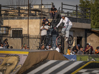 Iranian youths watch a young woman perform in a freestyle bicycle competition at the Navid BMX Bike Park in southern Tehran, Iran, on Octobe...