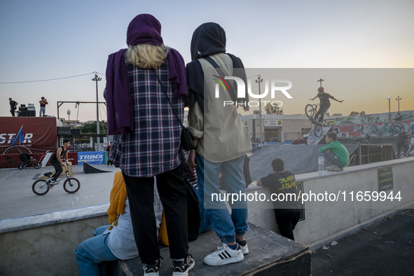 Iranian youths watch a participant perform in a freestyle bicycle competition at the Navid BMX Bike Park in southern Tehran, Iran, on Octobe...