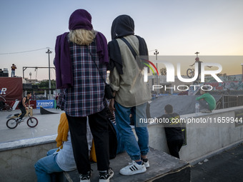 Iranian youths watch a participant perform in a freestyle bicycle competition at the Navid BMX Bike Park in southern Tehran, Iran, on Octobe...