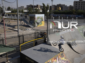 A young Iranian woman performs in a freestyle bicycle competition at the Navid BMX Bike Park in southern Tehran, Iran, on October 11, 2024....