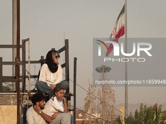 Iranian youths watch a freestyle bicycle competition at the Navid BMX Bike Park in southern Tehran, Iran, on October 11, 2024. (