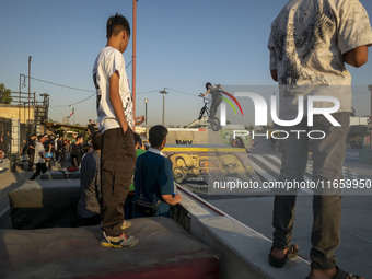 Iranian youths watch a participant perform in a freestyle bicycle competition at the Navid BMX Bike Park in southern Tehran, Iran, on Octobe...