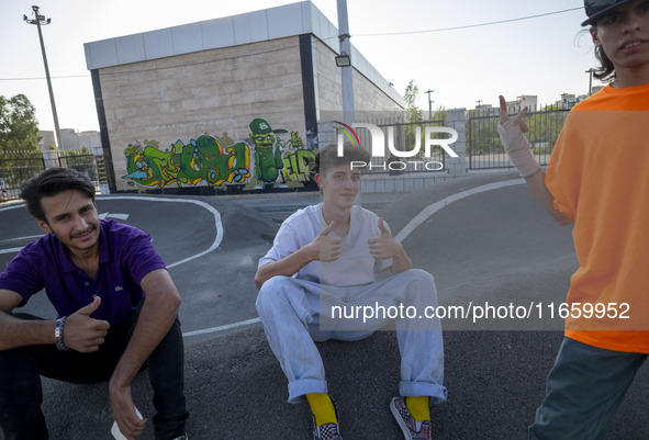 Iranian participants (R) and (C) react while waiting to perform in a freestyle bicycle competition at the Navid BMX Bike Park in southern Te...