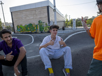 Iranian participants (R) and (C) react while waiting to perform in a freestyle bicycle competition at the Navid BMX Bike Park in southern Te...