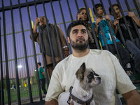 An Iranian man hugs his pet while watching a freestyle bicycle competition at the Navid BMX Bike Park in southern Tehran, Iran, on October 1...