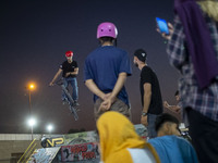 Iranian youths watch a participant perform in a freestyle bicycle competition at the Navid BMX Bike Park in southern Tehran, Iran, on Octobe...