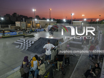 Iranian youths watch a participant perform in a freestyle bicycle competition at the Navid BMX Bike Park in southern Tehran, Iran, on Octobe...