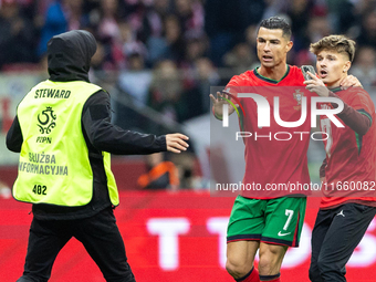 A pitch invader takes a selfie photograph with Portugal forward Cristiano Ronaldo during the  UEFA Nations League 2024 League A Group A1 mat...