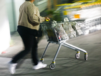 A person walks with a shopping trolley near the shop in Inwald, Poland on October 12, 2024. (