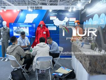 Visitors communicate with exhibitors at the 9th China Advanced Materials Industry Expo 2024 in Qingdao, China, on October 12, 2024. (