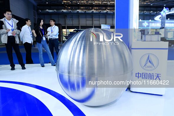 Visitors look at a titanium alloy storage box for the Chang 'e lunar probe at the 9th China Advanced Materials Industry Expo 2024 in Qingdao...