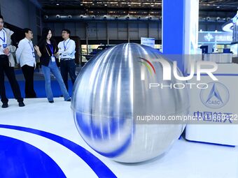 Visitors look at a titanium alloy storage box for the Chang 'e lunar probe at the 9th China Advanced Materials Industry Expo 2024 in Qingdao...