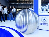 Visitors look at a titanium alloy storage box for the Chang 'e lunar probe at the 9th China Advanced Materials Industry Expo 2024 in Qingdao...