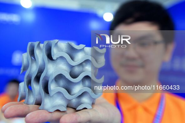 An exhibitor displays a 3D printed aluminum alloy lattice structure at the 9th China Advanced Materials Industry Expo 2024 in Qingdao, China...