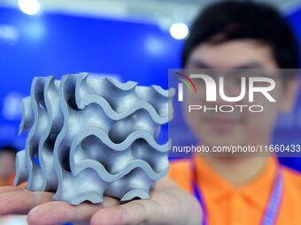 An exhibitor displays a 3D printed aluminum alloy lattice structure at the 9th China Advanced Materials Industry Expo 2024 in Qingdao, China...