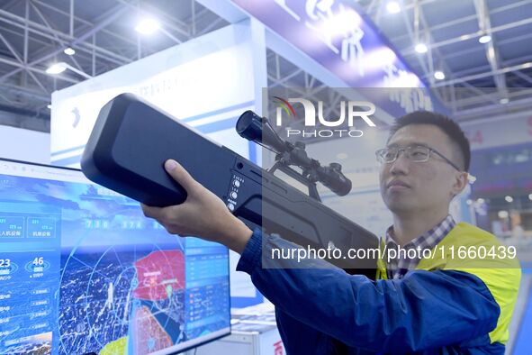 An exhibitor displays unmanned aerial vehicle (UAV) control equipment at the 9th China Advanced Materials Industry Expo 2024 in Qingdao, Chi...