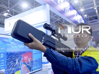 An exhibitor displays unmanned aerial vehicle (UAV) control equipment at the 9th China Advanced Materials Industry Expo 2024 in Qingdao, Chi...