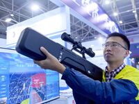 An exhibitor displays unmanned aerial vehicle (UAV) control equipment at the 9th China Advanced Materials Industry Expo 2024 in Qingdao, Chi...