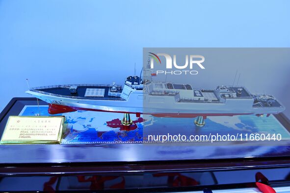 An exhibitor shows a model of a Type 055 destroyer at the 9th China Advanced Materials Industry Expo 2024 in Qingdao, China, on October 12,...