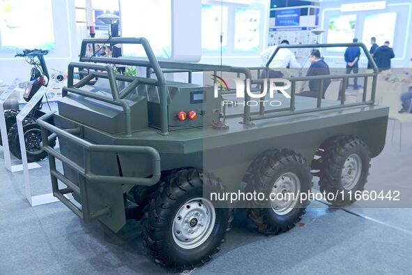 An exhibitor shows a guarantee following an unmanned vehicle at the 9th China Advanced Materials Industry Expo 2024 in Qingdao, China, on Oc...