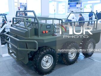 An exhibitor shows a guarantee following an unmanned vehicle at the 9th China Advanced Materials Industry Expo 2024 in Qingdao, China, on Oc...