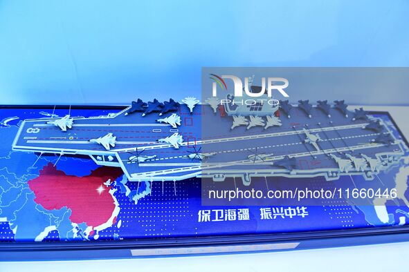 An exhibitor shows a model of the aircraft carrier Fujian at the 9th China Advanced Materials Industry Expo 2024 in Qingdao, China, on Octob...