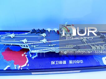 An exhibitor shows a model of the aircraft carrier Fujian at the 9th China Advanced Materials Industry Expo 2024 in Qingdao, China, on Octob...