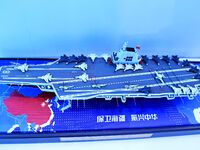 An exhibitor shows a model of the aircraft carrier Fujian at the 9th China Advanced Materials Industry Expo 2024 in Qingdao, China, on Octob...