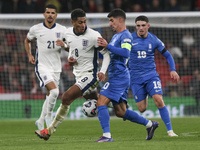 Jude Bellingham of England and Petros Mantalos of Greece compete for the ball during the football game between England and Greece for the UE...