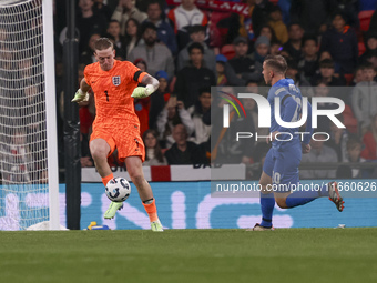 Goalkeeper Jordan Pickford of England holds the ball as Dimitris Pelkas of Greece is in action during the football game between England and...