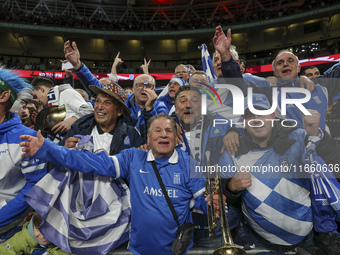 Fans of the Greek football team cheer, sing, and celebrate after the historic win. The football game between England and Greece for the UEFA...