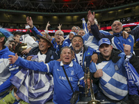 Fans of the Greek football team cheer, sing, and celebrate after the historic win. The football game between England and Greece for the UEFA...