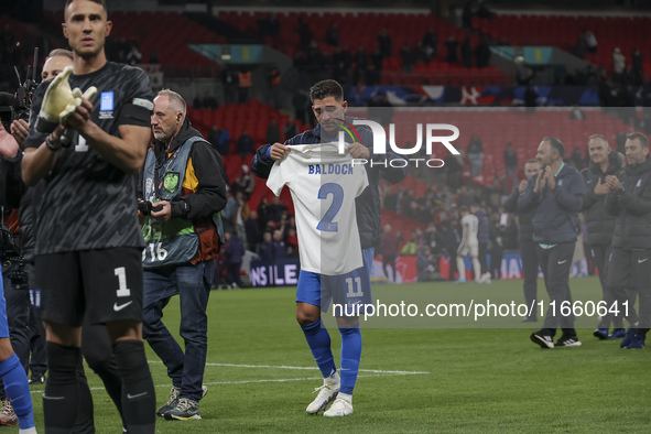 Tasos Bakasetas holds an official jersey with the name BALDOCK while he appears emotional. The Greek team heads to the Greek fans to celebra...